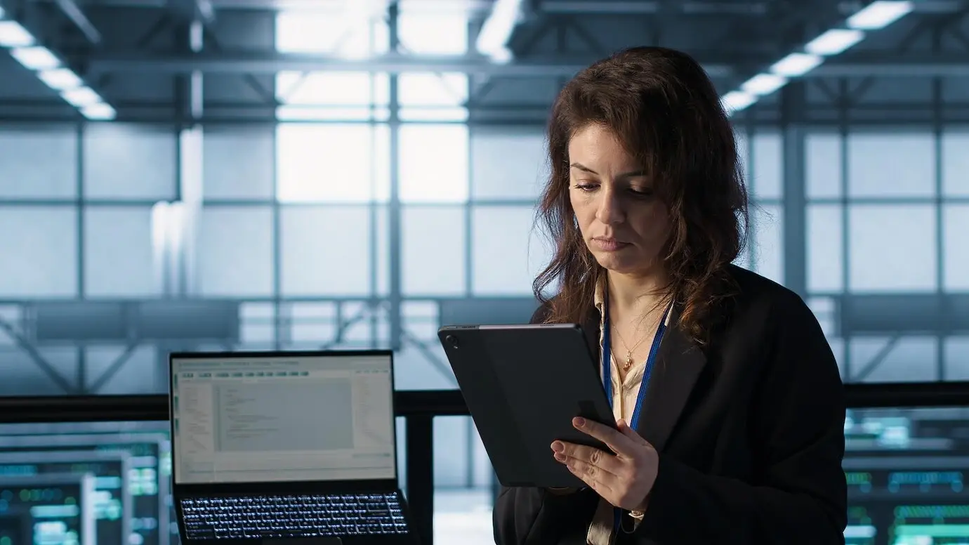 Administrador en un centro de datos usando tecnología de inteligencia artificial en una tableta.